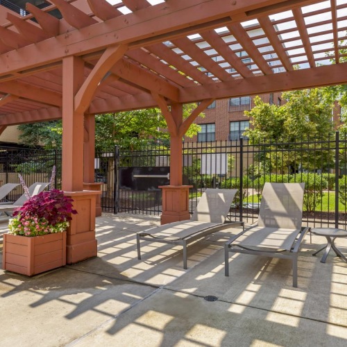 a covered patio with a bench and a fence